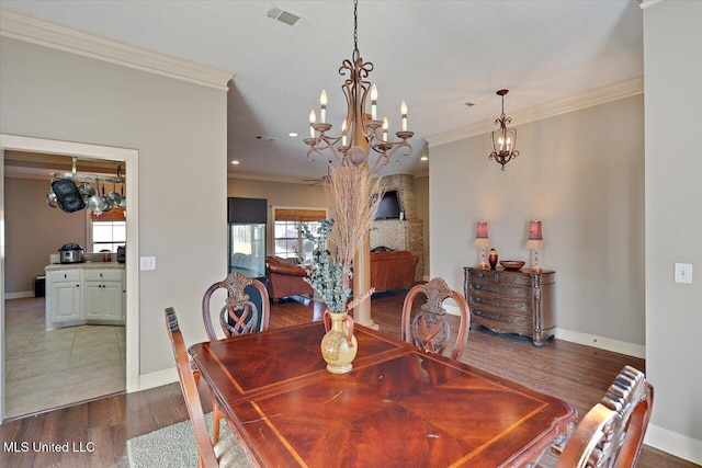 dining room featuring wood-type flooring, ornamental molding, and a chandelier