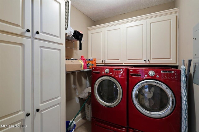 clothes washing area featuring separate washer and dryer, a textured ceiling, and cabinets