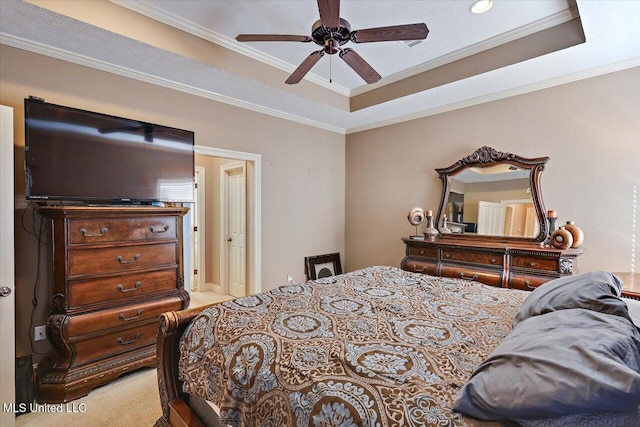 carpeted bedroom featuring ceiling fan, ornamental molding, and a raised ceiling