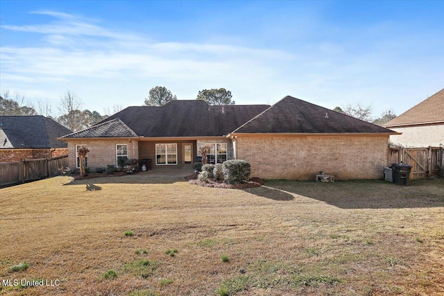 rear view of property featuring a lawn