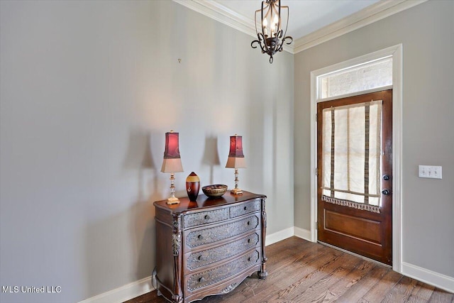 foyer entrance with crown molding, hardwood / wood-style floors, and a notable chandelier