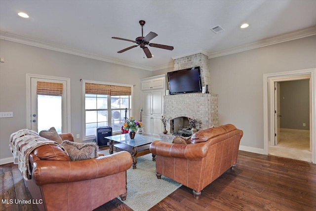 living room featuring a brick fireplace, crown molding, and ceiling fan