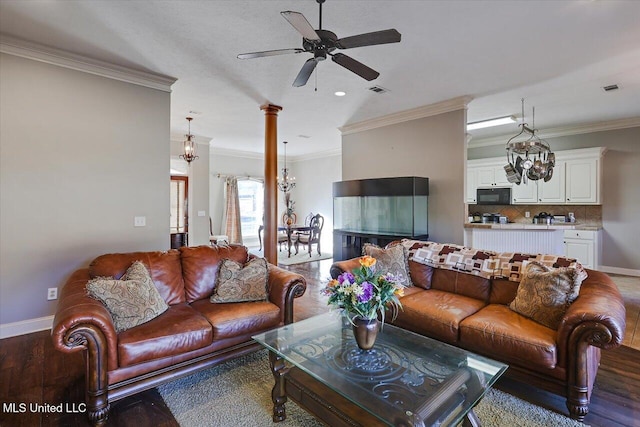 living room with crown molding, dark hardwood / wood-style floors, and decorative columns