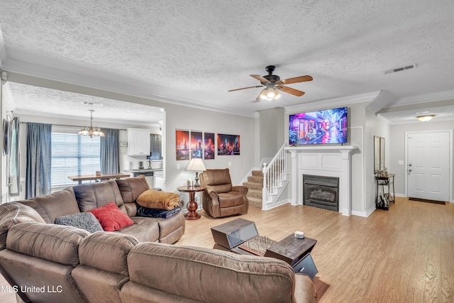 1201 Arbor Hill Dr, Brandon, MS 39042 - living area featuring a textured ceiling, light wood finished floors, ornamental molding, ceiling fan, and a glass covered fireplace