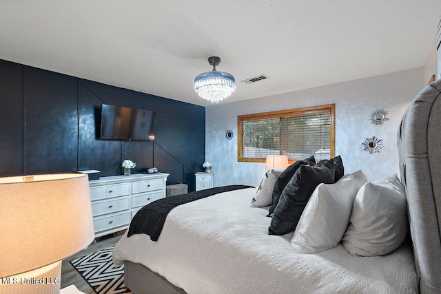 bedroom with hardwood / wood-style flooring and a chandelier