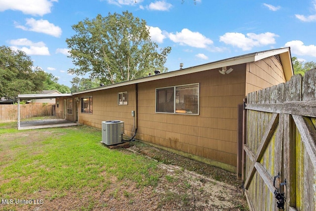 back of property featuring central air condition unit, a patio, and a lawn