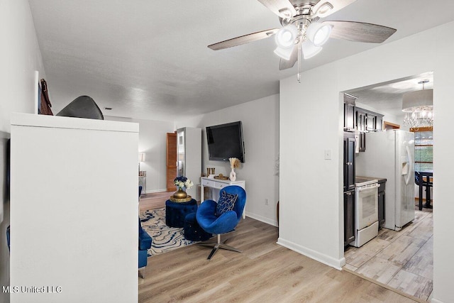 sitting room featuring light hardwood / wood-style floors, a textured ceiling, and ceiling fan