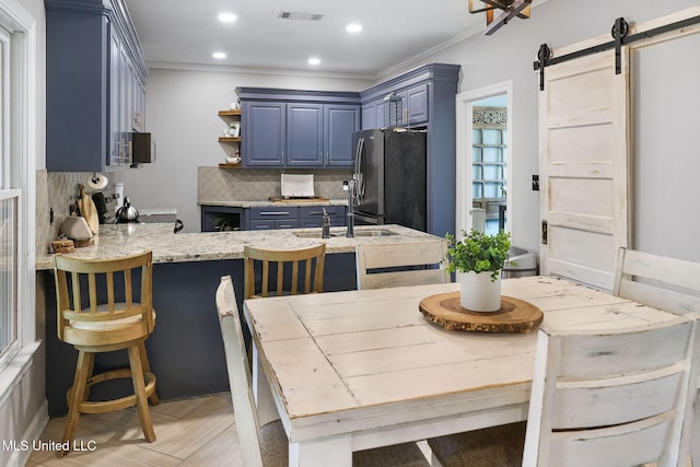 108 Kenbridge Ln, Madison, MS 39110 - kitchen with blue cabinetry, decorative backsplash, a barn door, a peninsula, and appliances with stainless steel finishes
