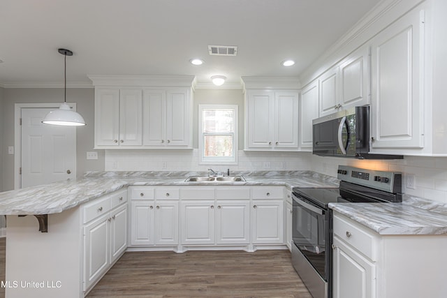 kitchen featuring a breakfast bar area, kitchen peninsula, white cabinets, and appliances with stainless steel finishes