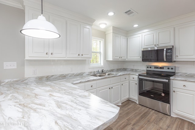 kitchen featuring sink, tasteful backsplash, decorative light fixtures, appliances with stainless steel finishes, and white cabinets