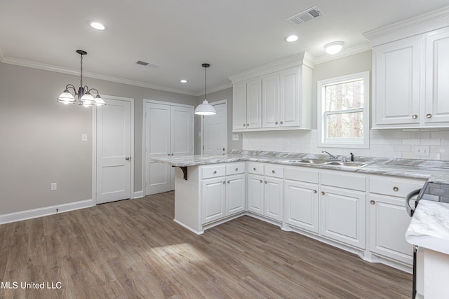 kitchen featuring white cabinetry, ornamental molding, and pendant lighting