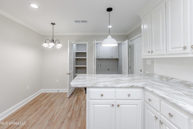 kitchen with ornamental molding, light hardwood / wood-style floors, and white cabinets