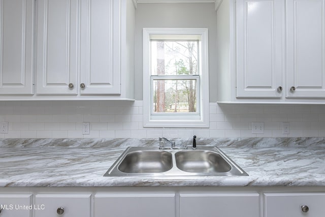 kitchen featuring white cabinetry, sink, and decorative backsplash