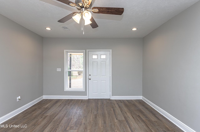 entrance foyer with ceiling fan, dark wood-type flooring, and a textured ceiling