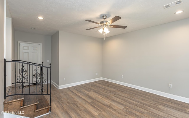 unfurnished room featuring dark wood-type flooring, ceiling fan, and a textured ceiling