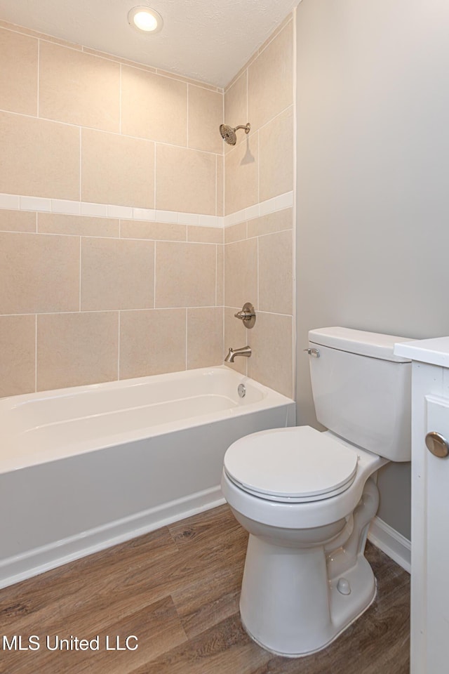 full bathroom with vanity, toilet, tiled shower / bath combo, and hardwood / wood-style floors