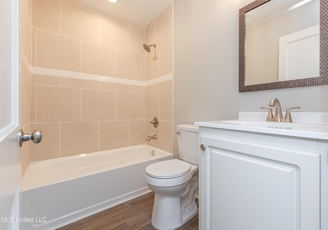 full bathroom with tiled shower / bath combo, vanity, hardwood / wood-style flooring, and toilet