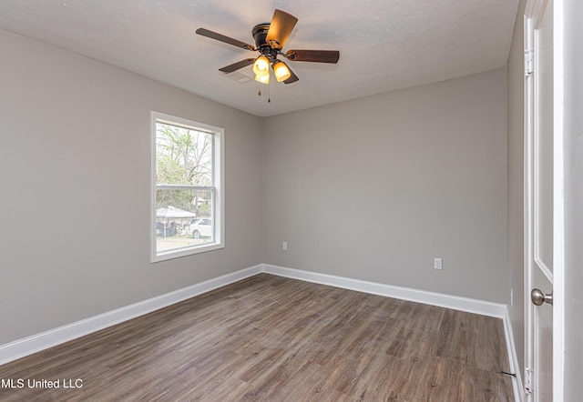 unfurnished room featuring ceiling fan, dark hardwood / wood-style floors, and a textured ceiling