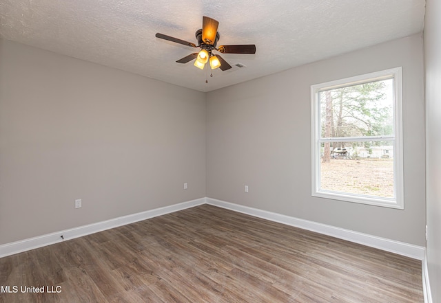 empty room with a textured ceiling, dark hardwood / wood-style floors, and ceiling fan