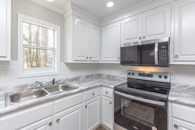 kitchen with sink, backsplash, white cabinets, and appliances with stainless steel finishes