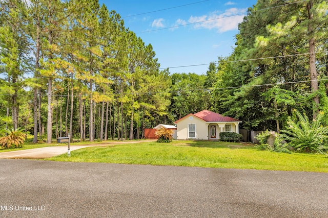 3005 Robalo Dr, Gautier, MS 39553 - view of front of house with stucco siding, concrete driveway, and a view of trees