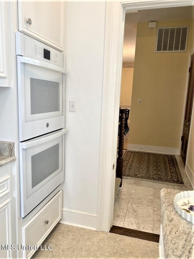 707 State St Unit 705, Natchez, MS 39120 - kitchen featuring white double oven, white cabinets, baseboards, and light tile patterned floors