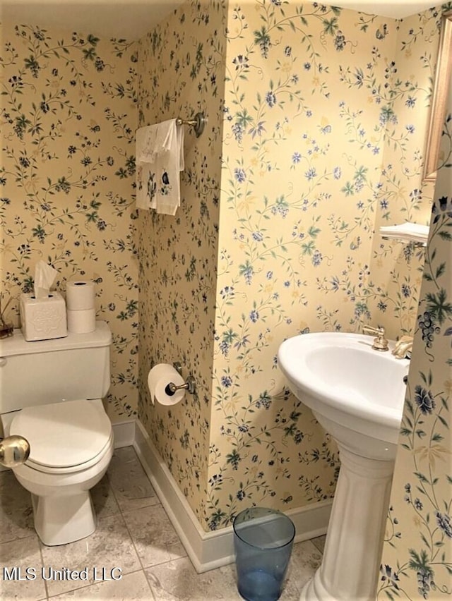 707 State St Unit 705, Natchez, MS 39120 - half bathroom with wallpapered walls, toilet, baseboards, and tile patterned floors
