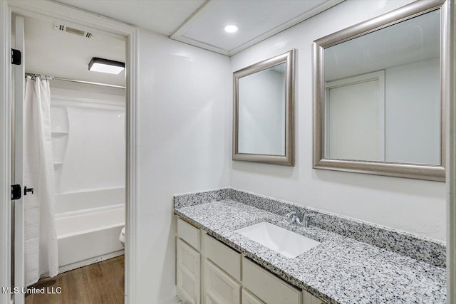 full bathroom featuring vanity, wood-type flooring, shower / bath combination with curtain, and toilet