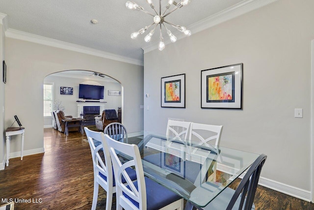 30 Charleston Cir, Brandon, MS 39047 - dining area featuring arched walkways, crown molding, a fireplace, dark wood finished floors, and a chandelier