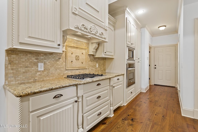 130 Camden Xing, Madison, MS 39110 - kitchen with appliances with stainless steel finishes, dark wood-style flooring, backsplash, white cabinetry, and ornamental molding