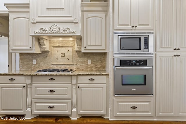 130 Camden Xing, Madison, MS 39110 - kitchen featuring appliances with stainless steel finishes, decorative backsplash, and light stone counters