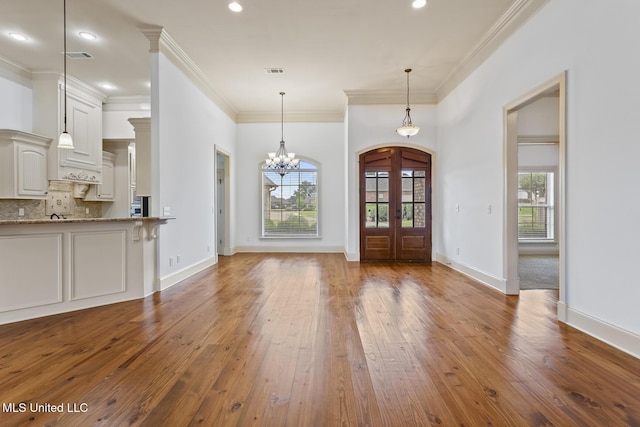 130 Camden Xing, Madison, MS 39110 - entryway featuring hardwood / wood-style flooring, plenty of natural light, a chandelier, arched walkways, and crown molding