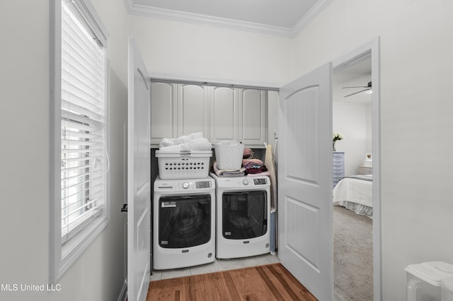 washroom featuring washing machine and clothes dryer, cabinets, ornamental molding, ceiling fan, and hardwood / wood-style floors