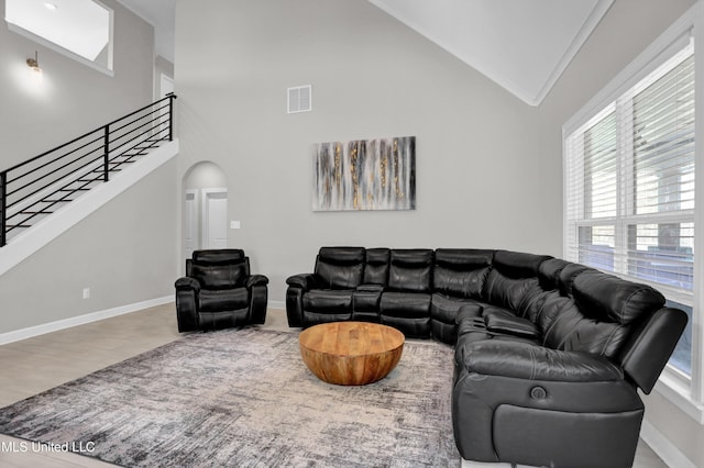 living room with high vaulted ceiling, wood-type flooring, and ornamental molding