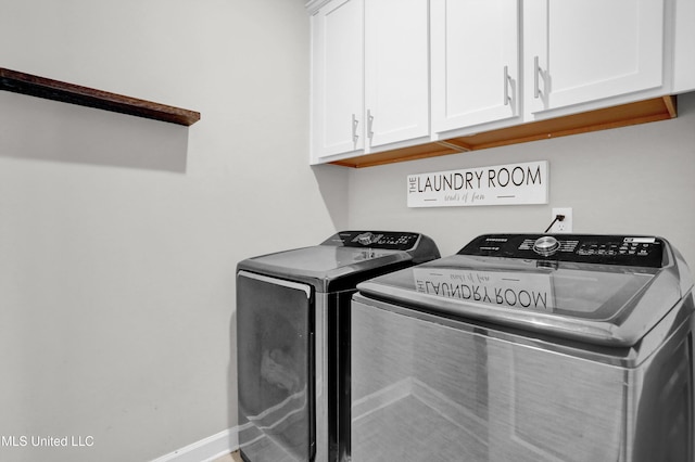 laundry area with washing machine and clothes dryer and cabinets