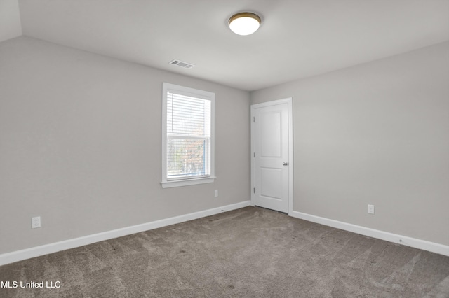 carpeted spare room with lofted ceiling