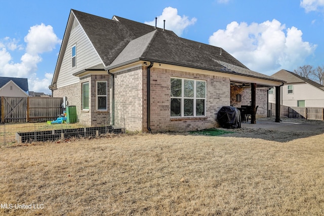 rear view of house featuring a yard and a patio