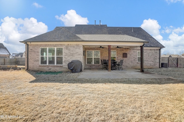 rear view of house with ceiling fan, a yard, and a patio