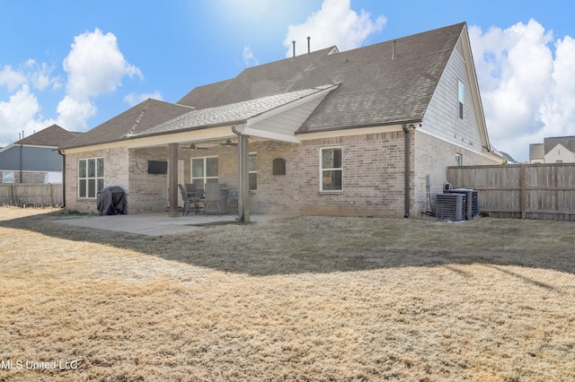 rear view of house featuring cooling unit, a yard, and a patio