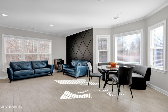 living room featuring ornamental molding, light hardwood / wood-style flooring, and plenty of natural light