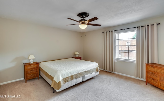 bedroom with light colored carpet, baseboards, and ceiling fan