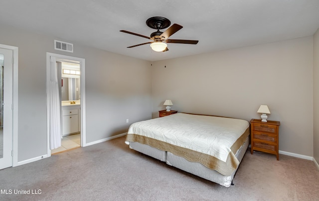 bedroom with light carpet, baseboards, ceiling fan, and connected bathroom