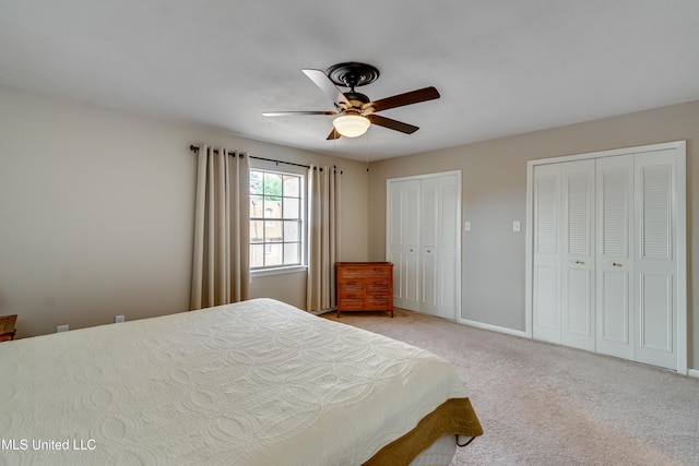bedroom with multiple closets, light carpet, a ceiling fan, and baseboards