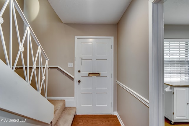foyer entrance with wood finished floors and baseboards