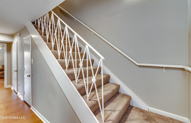 stairs with baseboards and wood finished floors