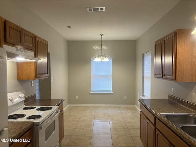 kitchen featuring dark countertops, visible vents, under cabinet range hood, white electric range, and a sink