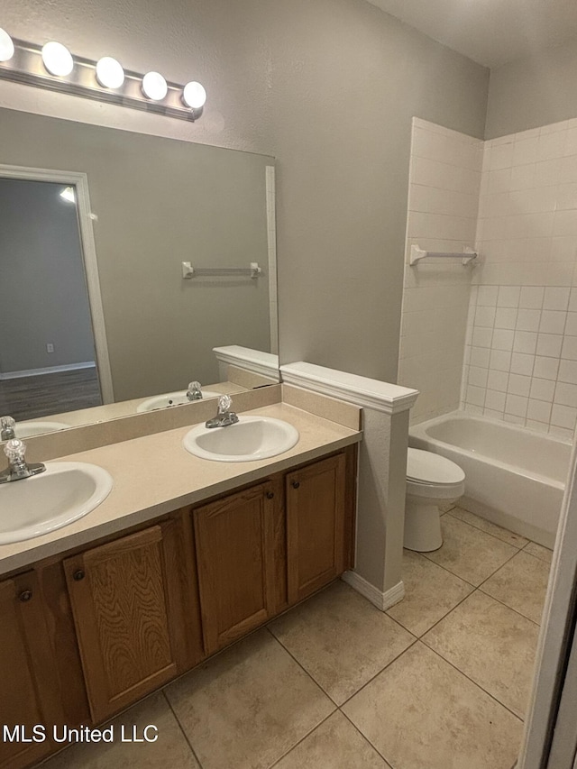 bathroom featuring a sink, toilet, double vanity, and tile patterned flooring