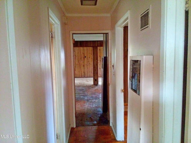 hallway with crown molding and wood walls