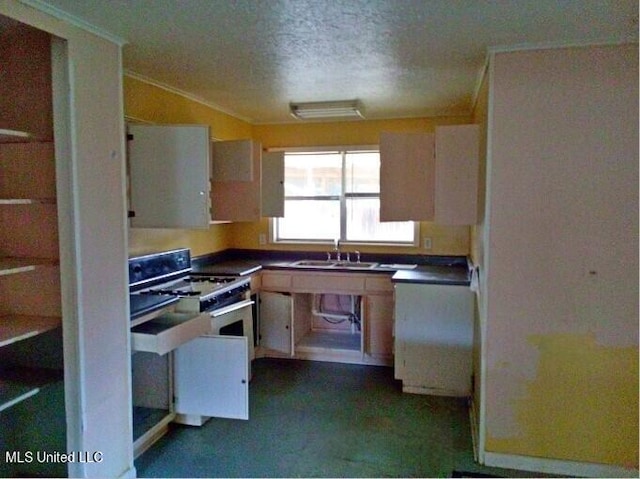 kitchen with white gas range, stainless steel gas stove, sink, white cabinets, and a textured ceiling