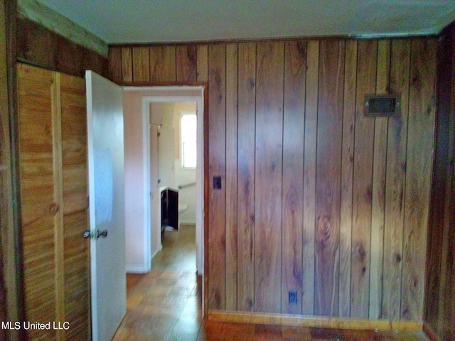 hall with wooden walls and light wood-type flooring